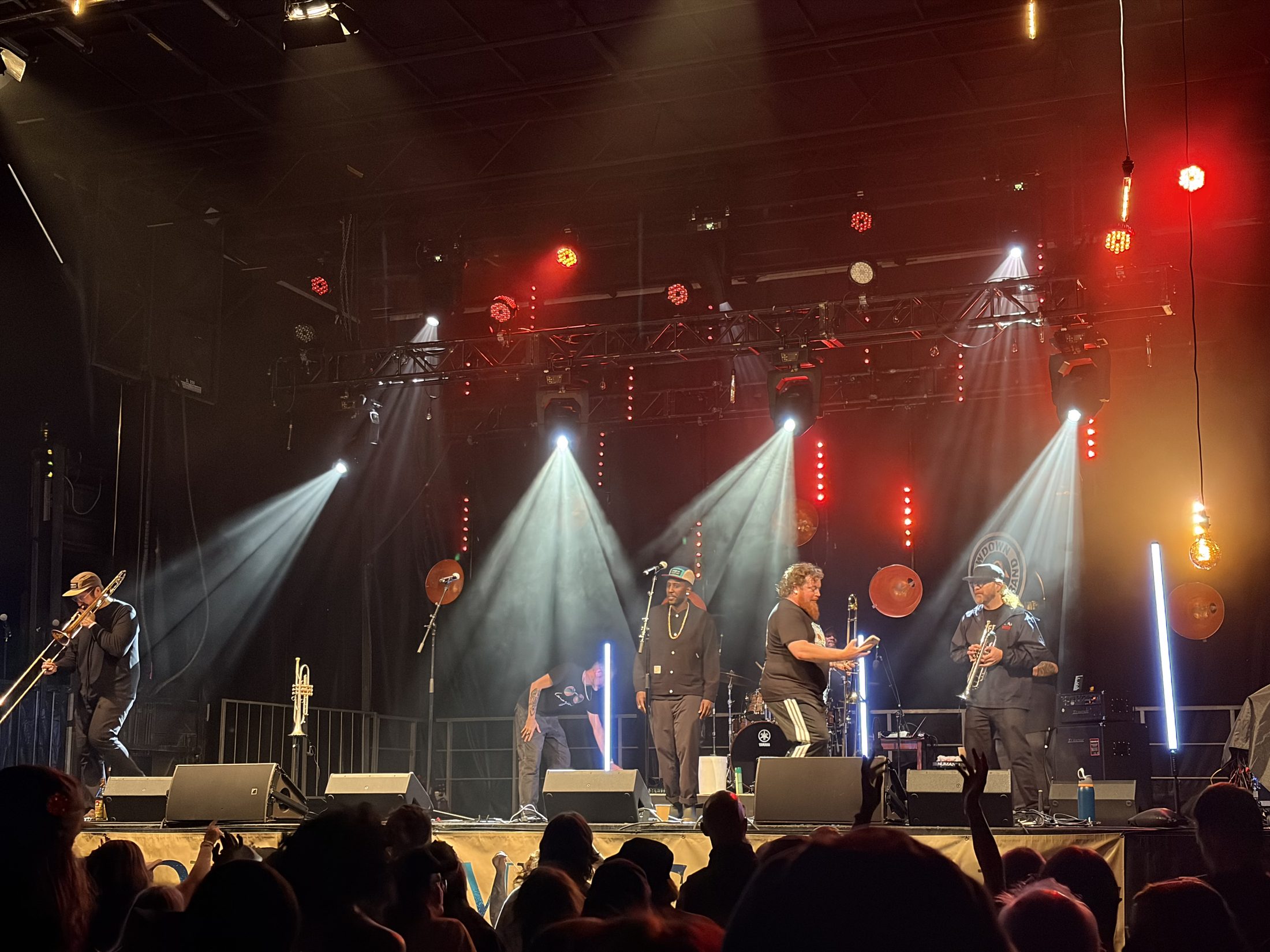 Live band performing under red and white concert lighting with truss-mounted moving lights, stage sound and lighting by Valley Tech