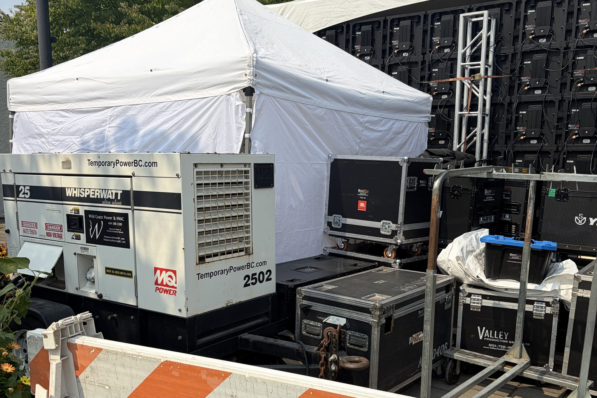 WhisperWatt diesel generator, Valley Tech Production Group road cases and an LED video wall at a Lower Mainland outdoor event — event power distribution on site